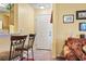 Inviting entryway with a white front door, warm yellow walls, and bar stools at 2276 Essex Dr. # H, Surfside Beach, SC 29575