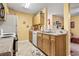 A compact kitchen with light wood cabinetry, white appliances, and a neutral countertop at 2276 Essex Dr. # H, Surfside Beach, SC 29575