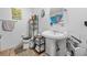 Bright bathroom features a pedestal sink, toilet, shelving unit, and a unique wall-mounted mirror at 2601 Rosehip Ct., Conway, SC 29527