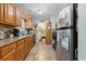 Galley kitchen featuring wood cabinets, tile backsplash, stainless steel fridge and tiled floor at 2601 Rosehip Ct., Conway, SC 29527