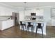 Modern kitchen features a large island with seating, stainless appliances, and sleek white cabinets at 2612 Watershed Way, North Myrtle Beach, SC 29568