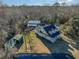Aerial view of a charming yellow home, large outbuilding, and a tranquil pond nestled in a wooded landscape at 2724 A C Ln, Conway, SC 29526