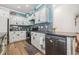 Charming kitchen boasts distressed cabinets, black appliances, and stylish gray backsplash at 2724 A C Ln, Conway, SC 29526