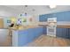 Well-lit kitchen with blue cabinets, a breakfast bar, and laminate countertops and floors at 340 Lands End Blvd. # 18, Myrtle Beach, SC 29572