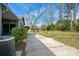 View of the backyard showing an established lawn, trees, and concrete path at 3807 Casey St., Loris, SC 29569