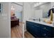Stylish bathroom with dark blue vanity, marble countertop, and a glimpse into the bedroom at 4239 Rivergate Ln., Little River, SC 29566