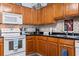 Kitchen with wood cabinets, black countertops, white appliances and tile backsplash at 4239 Rivergate Ln., Little River, SC 29566