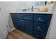 Modern vanity with blue cabinetry, marble countertop, and decorative accessories at 4239 Rivergate Ln., Little River, SC 29566