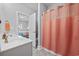 Bathroom featuring a vanity with a sink and an adjacent shower with peach colored curtain and open access to bedroom at 430 7Th Ave. S, North Myrtle Beach, SC 29582