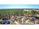 Aerial view of homes surrounded by mature trees and foliage, a golf course in the distance at 4494 Aberdeen Way, Myrtle Beach, SC 29579