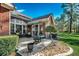Brick home with a cozy outdoor patio seating area with mature trees and landscaping at 4494 Aberdeen Way, Myrtle Beach, SC 29579