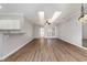 Bright living room with wood-look floors, modern light fixture, serving bar, and tray ceiling at 4535 Lightkeepers Dr. # 27B, Little River, SC 29566