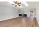 Bright living room featuring wood-look floors, a ceiling fan, modern light fixture, and mirrored wall at 4535 Lightkeepers Dr. # 27B, Little River, SC 29566
