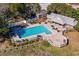 Aerial view of the community pool with lounge chairs, a deck and manicured landscaping at 48 Twelve Oaks Dr. # 3, Pawleys Island, SC 29585