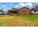 Back exterior view of brick home with a screen porch and a fenced backyard at 4908 Main St., Loris, SC 29569