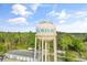 A daytime aerial view of the Loris, SC water tower in front of a tree lined background at 4908 Main St., Loris, SC 29569