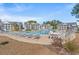 Resort-style pool with ample lounge seating surrounded by lush landscaping and manicured grounds at 4929 Pond Shoals Ct. # 201, Myrtle Beach, SC 29579