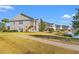 Exterior shot of townhomes situated along a picturesque pond, with well-maintained landscaping at 4929 Pond Shoals Ct. # 201, Myrtle Beach, SC 29579