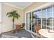 Relaxing balcony with seating, a decorative palm tree and sliding glass doors at 5801 Oyster Catcher Dr. # 822, North Myrtle Beach, SC 29582