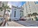 Condo building exterior view featuring a parking area and palm trees at 5801 Oyster Catcher Dr. # 822, North Myrtle Beach, SC 29582