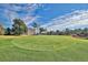 Beautiful golf course green, surrounded by lush trees, under a vivid blue sky with a home in the background at 5801 Oyster Catcher Dr. # 822, North Myrtle Beach, SC 29582