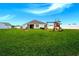 Spacious backyard featuring a well-maintained lawn, a playset, and a partial view of the home's exterior at 519 Grass Fern Ct., Longs, SC 29568
