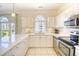 Bright kitchen featuring white cabinets, stainless steel appliances, and tile flooring at 670 Riverwalk Dr. # 304, Myrtle Beach, SC 29579