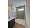 This modern bathroom offers a walk-in shower with vertical tile and a marble topped vanity with dark wood cabinets at 713 9Th Ave. S, North Myrtle Beach, SC 29582