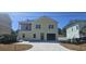 Two-story yellow home with a garage and a long concrete driveway on a sunny day at 713 9Th Ave. S, North Myrtle Beach, SC 29582