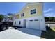 Two-story yellow and white home with a concrete driveway and two-car garage, perfect for coastal living at 713 9Th Ave. S, North Myrtle Beach, SC 29582
