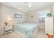 Bright bedroom features a queen-size bed with a decorative floral patterned comforter and a ceiling fan at 8538 Hopkins Circle # E, Surfside Beach, SC 29575
