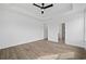 Bedroom features wood-look floors, multiple windows, tray ceiling, and open doorways to other rooms at 885 Bear Lake Dr., Longs, SC 29568
