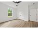 Bright bedroom featuring hardwood floors, a ceiling fan and a large window with a view of the outdoors at 885 Bear Lake Dr., Longs, SC 29568