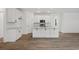 Bright kitchen features white cabinets, stainless appliances, and a center island with wood-look floors at 885 Bear Lake Dr., Longs, SC 29568
