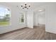 Sunlit living room with elegant hardwood floors and a modern chandelier at 885 Bear Lake Dr., Longs, SC 29568