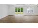 Modern living room with hardwood floors, a sliding glass door, and abundant natural light at 885 Bear Lake Dr., Longs, SC 29568
