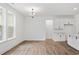 Bright living room with wood-look flooring, modern light fixture, and large windows for natural light at 885 Bear Lake Dr., Longs, SC 29568