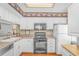 Functional kitchen with white cabinets, a microwave, range, and refrigerator at 914 Hillside Dr. S # O, North Myrtle Beach, SC 29582