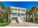 Two-story coastal home with dual balconies, palm trees, and driveway at 1006 Clubhouse Dr., North Myrtle Beach, SC 29582