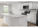 Modern kitchen with stainless steel appliances, white cabinetry, quartz countertops, and a large center island at 1079 Oak Meadow Dr., Conway, SC 29526