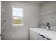 Bright laundry room featuring a modern washer and dryer, built-in shelving, and a large window at 1079 Oak Meadow Dr., Conway, SC 29526