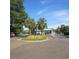 Welcoming community entrance featuring colorful flowers, palm trees, and a secure gate for residents at 135 S Dunes Dr., Pawleys Island, SC 29585