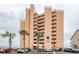 Exterior of the Carolina Reef condo building with palm trees in front of the parking area at 1501 S Ocean Blvd. # 504, North Myrtle Beach, SC 29582