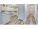 Well-lit kitchen with white cabinets, modern appliances, and hardwood floors adjoining the hallway at 1537 Lanterns Rest Rd. # 202, Myrtle Beach, SC 29579