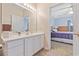 Well-lit main bathroom with a large mirror, white cabinets, and a doorway to the main bedroom at 1537 Lanterns Rest Rd. # 202, Myrtle Beach, SC 29579