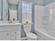 Well-lit bathroom featuring a white sink vanity, toilet and tub/shower with neutral blue colored walls at 1609 Seachase Way, North Myrtle Beach, SC 29582