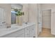 Bright bathroom with double sinks with chrome faucets, white cabinets, and a shower visible through an open door at 1609 Seachase Way, North Myrtle Beach, SC 29582