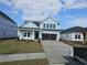 Charming two-story home with light blue siding, a modern black door, and a spacious two-car garage at 1609 Seachase Way, North Myrtle Beach, SC 29582