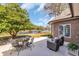 Relaxing backyard setup with patio furniture overlooking a serene lake and lush landscaping at 1616 Hawthorn Dr., Pawleys Island, SC 29585