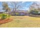 Expansive brick home with well-manicured lawn, mature trees, and a serene setting at 1616 Hawthorn Dr., Pawleys Island, SC 29585